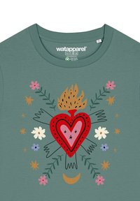 Grünes Baumwoll-T-Shirt mit einem zentralen roten Herzdesign, das von einer Flamme umgeben ist, sowie bunten Blumen und Blättern und dekorativen Sternen.