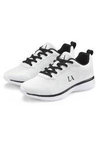 Weiße Sportschuhe mit schwarzen Akzenten, ausgestattet mit einem strukturierten Obermaterial, Schnürverschluss und einer leichten Sohle. Markenlogo an der Seite.