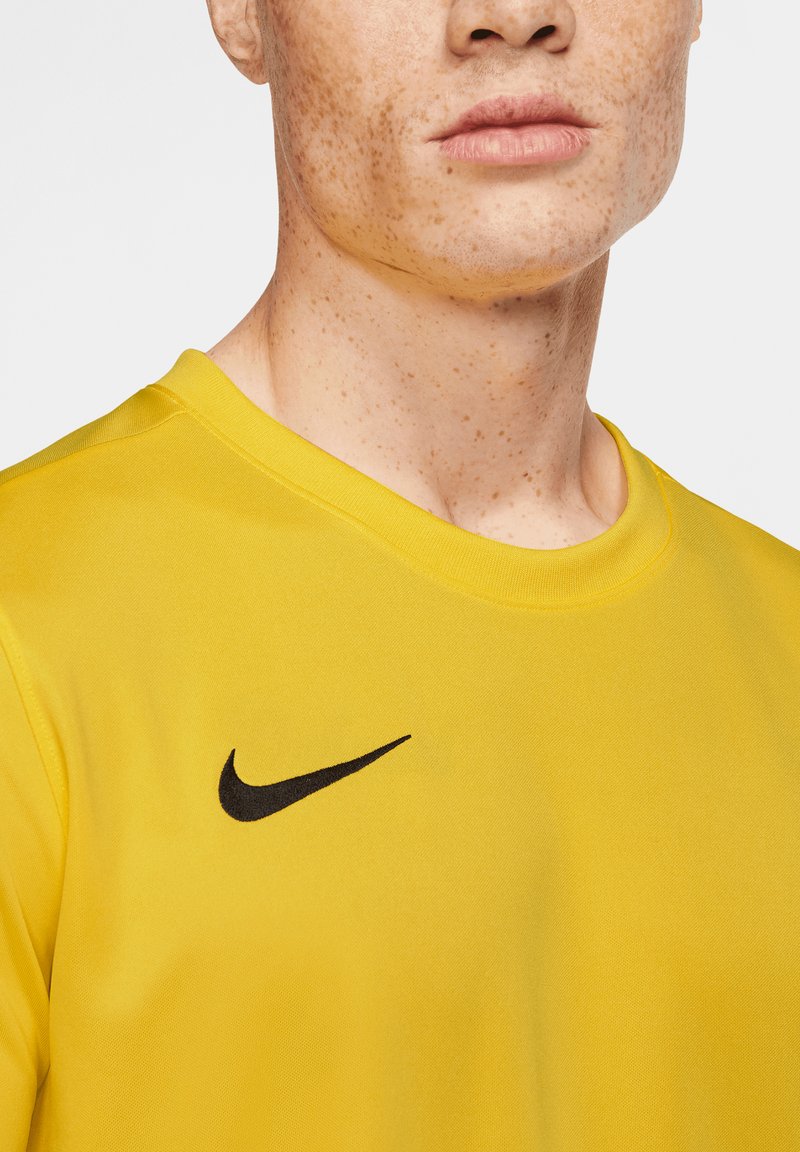T-shirt atletico giallo con scollatura rotonda, maniche corte e logo Nike nero sul lato sinistro del petto. Tessuto morbido.