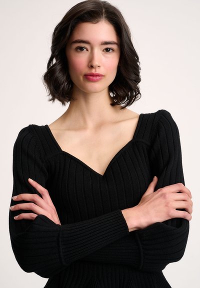 Schwarzer Rippstrick-Pullover mit V-Ausschnitt, langen Ärmeln und strukturierten Schultern. Besitzt eine figurbetonte Silhouette und eine strukturierte Stoffqualität.