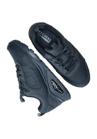 Sneakers Skechers di un blu navy scuro con una tomaia sintetica testurizzata, lacci frontali, collo imbottito e dettaglio di ammortizzazione visibile nella suola.