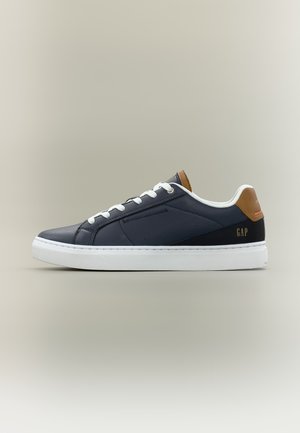 Navy blue low-top sneaker with white laces and sole, brown heel tab, and "GAP" logo on the side.
