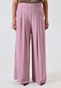 Plissé wijde pijpen broek in pastelroze, gemaakt van een zachte stof. Heeft een hoge tailleband en valt losjes tot op de vloer.