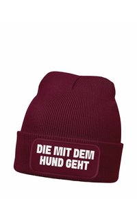 Burgundy knit beanie with ribbed texture and a folded cuff, featuring a white patch with the text "DIE MIT DEM HUND GEHT."