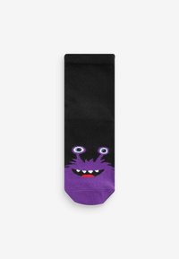 Musta sukka, jossa on sarjakuvamainen violetti monsteri -kuvio, jossa on isot silmät, terävät hampaat ja tekstuuriset yksityiskohdat violetissa alaosassa.
