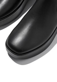 Zwarte leren schoenen met een gladde, glanzende textuur. Beschikt over een vierkante neus en een dikke, ronde zool voor stabiliteit en comfort.