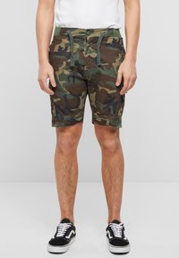 Karinės stiliaus šortai iš audinio, turinčio žalią, rudą ir juodą raštų mišinį. Turi reguliuojamą raištelį ir priekines kišenes.