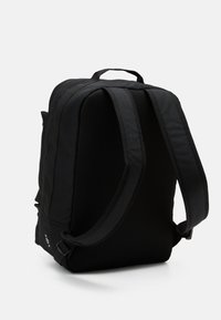 Musta reppu, jossa on rakenteellinen muotoilu, pehmustettu verkkoselkä ja -hihnat. Sisältää sivutaskun ja säädettävät kiinnitykset.