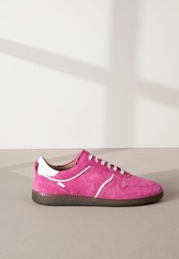 Roze suede tenisice s bijelim detaljima, teksturirana površina, zaobljeni vrh i ravni gumeni potplat. Imaju bijele vezice i minimalistički dizajn.