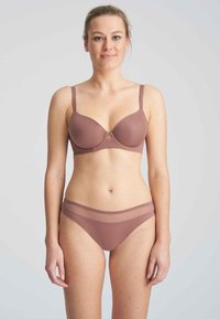 Conjunto de sujetador y bikini en un suave color malva, que presenta una tela suave, detalles transparentes en el bikini y tirantes ajustables en el sujetador.