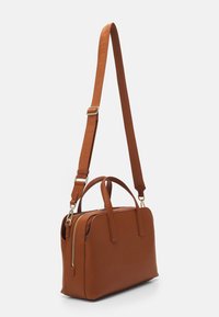 Ruskea nahkainen käsilaukku, jossa on kaksinkertaiset kahvat ja säädettävä olkahihna. Varustettu vetoketjullisella suljinnalla ja kullanvärisillä metalliosilla. Suorakulmainen muoto.