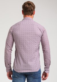 Camisa de manga larga en tela de color rosa texturizada con un patrón geométrico; cuenta con un cuello estándar y puños con botón. Vista trasera.