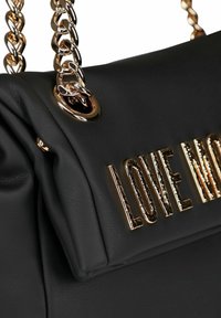 Borsa a tracolla in pelle nera con catene dorate e lettere dorate in rilievo che formano la parola "LOVE" sul risvolto anteriore.