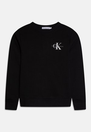 Sweat-shirt noir en tissu doux, avec un col rond et des poignets côtelés. Comprend un petit logo blanc sur la poitrine.
