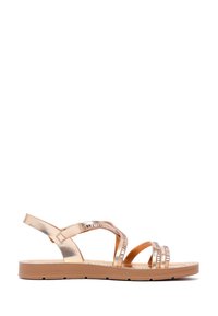 Sandali color oro rosa metallizzato con multiple cinghie, suola piatta color tan e accenti decorativi sulla parte superiore. Presentano una cinghia sul retro per una vestibilità sicura.
