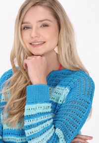 Könnyű, kötött pulóver kék és türkiz színben, nyitott szövésű csíkokkal, bordás mandzsettákkal és kerek nyakkivágással. Hétköznapi dizájn, sokoldalú textúra.