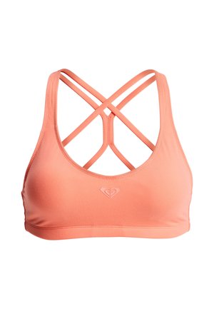 Sujetador deportivo color coral hecho de tela elástica, con un diseño de espalda cruzada y tirantes entrelazados, y un pequeño logo en el centro frontal.
