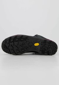 Suola di scarpa da trekking nera con un modello di battistrada resistente, un logo Vibram giallo e bordi in gomma rinforzati per durata e presa.