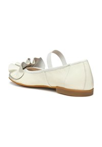 Bailarinas de cuero blanco con un detalle de punta con volantes y una correa elástica en el talón. Suela plana de goma marrón. Textura suave, diseño minimalista.
