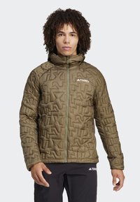 Olive green insulated jacket with a textured, geometric pattern. Features a full zipper, high collar, and branding on the chest.