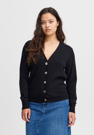 Cardigan noir avec un col en V, comportant six boutons ronds en argent sur le devant. Le tissu a une texture lisse et des manches longues.