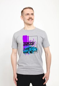 Šedé bavlněné tričko s výrazným potiskem modrého sportovního auta a fialovým a černým textem. Krátké rukávy a design s kulatým výstřihem.