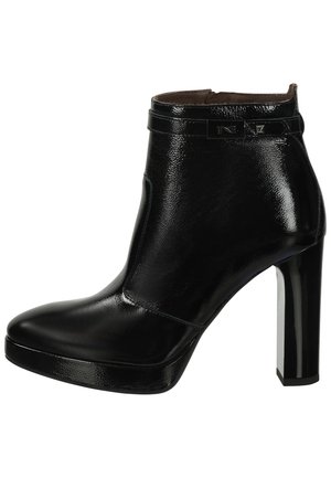 Black patent leather ankle boot with a pointed toe, high platform, and stiletto heel. Features a decorative strap and logo detail.