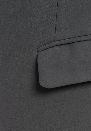 Tmavobéžová tkanina s hladkým povrchom a jemným diagonálnym pruhovým vzorom. Obsahuje detail prehnutého okraja na vrchu.