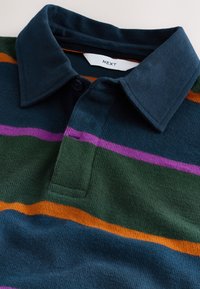 Bavlněné polo tričko s tmavě modrým límečkem a knoflíkem, s vodorovnými pruhy v zelené, fialové, oranžové a modré barvě. Žebrovaná textura.