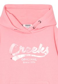 Felpa rosa realizzata in tessuto morbido, dotata di un logo riflettente argento "Creeks Original Since 1974" sul petto e di una tasca frontale.