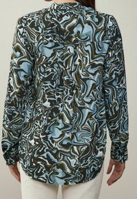 Camicia a maniche lunghe caratterizzata da un motivo astratto fluido nei toni del blu, verde e nero. Con colletto e polsini con bottone, realizzata in tessuto leggero.