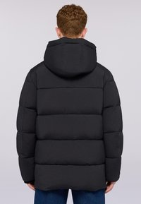 Svart puffjacka med huva, horisontellt quiltat mönster och elastiska ärmslut. Designen är lätt och isolerad för att ge värme.