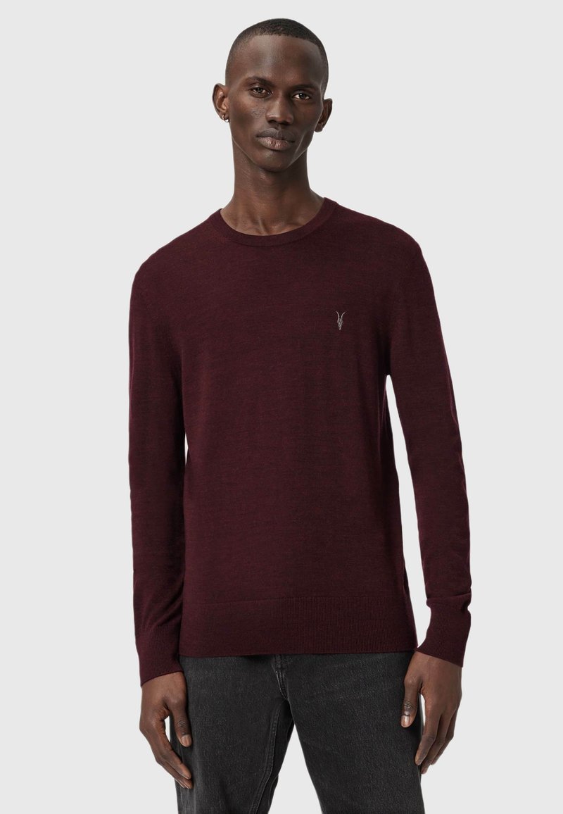 Maglione bordeaux a maniche lunghe realizzato in materiale morbido, con scollatura a girocollo e un logo discreto sul lato sinistro del petto.