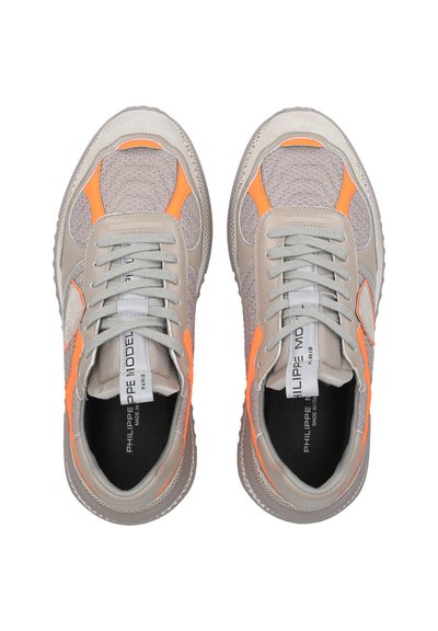 Jasnoszare sneakersy z siateczkowej cholewki, pomarańczowe akcenty, zaokrąglony czubek i teksturowane wykończenie. Zapięcie na sznurowadła z płaskimi sznurków.