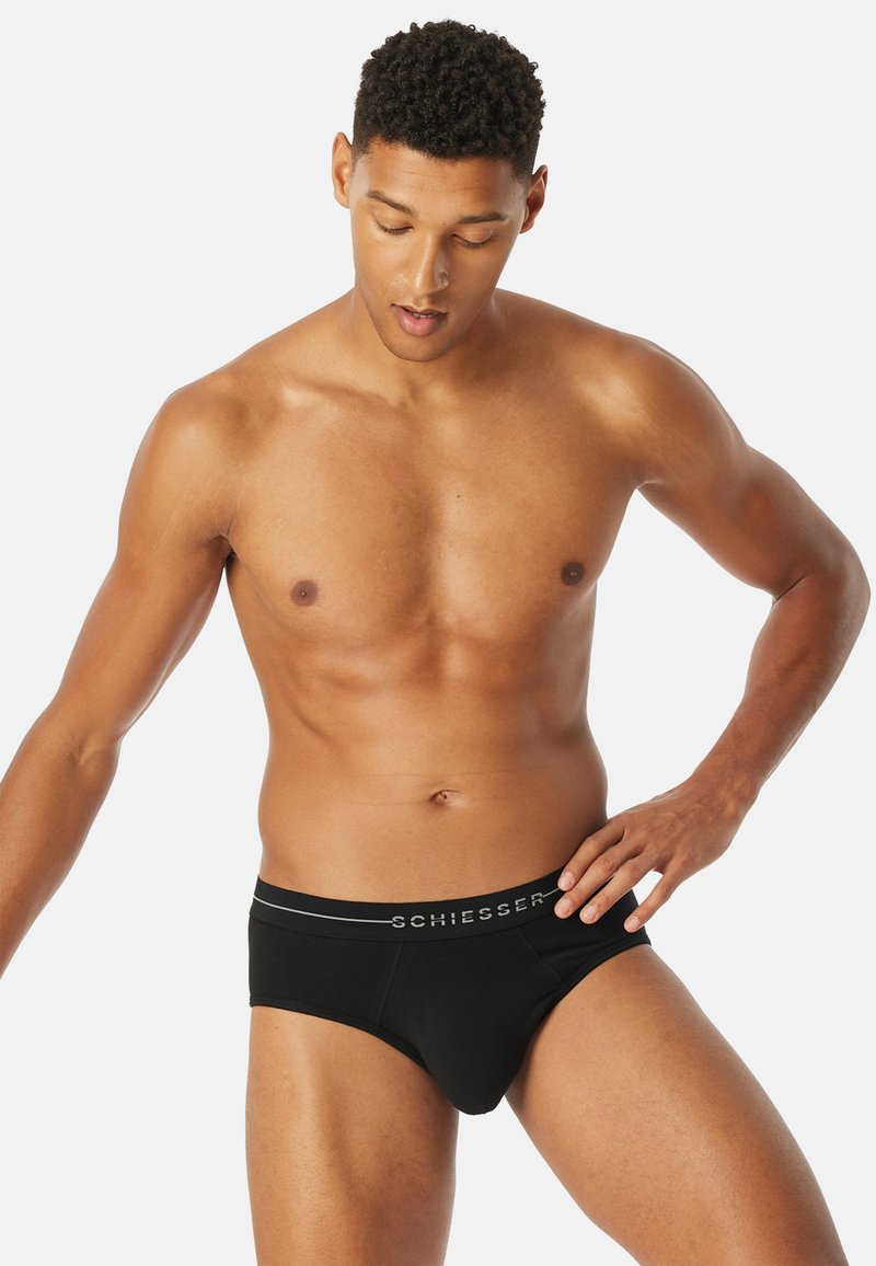 Zwarte katoenen slips met een gladde textuur, voorzien van een grijze logo-taillband en een contour pouch ontwerp voor ondersteuning en pasvorm.