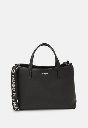 Black leather tote bag with dual top handles and detachable strap featuring a logo on the front and textured surface. Zipper closure detail.