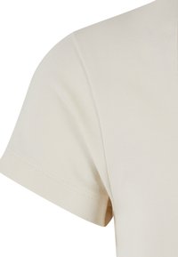 Kortärmad beige t-shirt tillverkad av mjuk bomull, med rund halsringning och slät yta, med rena sömmar längs kanterna.