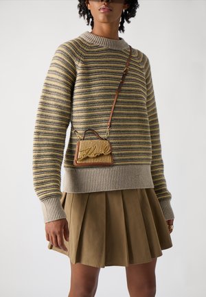 Gestreepte gebreide trui met ribbelboord, gecombineerd met een geplooide khaki rok. Bevat een kleine geweven schoudertas met metalen accenten.