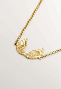 Collar de oro con un colgante en forma de ala con intrincados detalles de plumas, unido a una cadena texturizada.