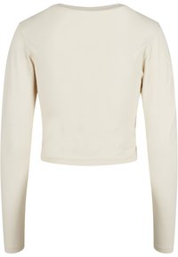 Vaaleanbeige lyhythihainen toppi, jossa on pyöreä pääntie, valmistettu sileästä kankaasta, ja se on suunniteltu minimalistisesti ilman koristeita.