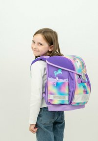 Lila Rucksack mit einem Einhornmotiv, schimmernden Akzenten, Netzträgern, einer Fronttasche und einem reflektierenden Streifen am Boden.