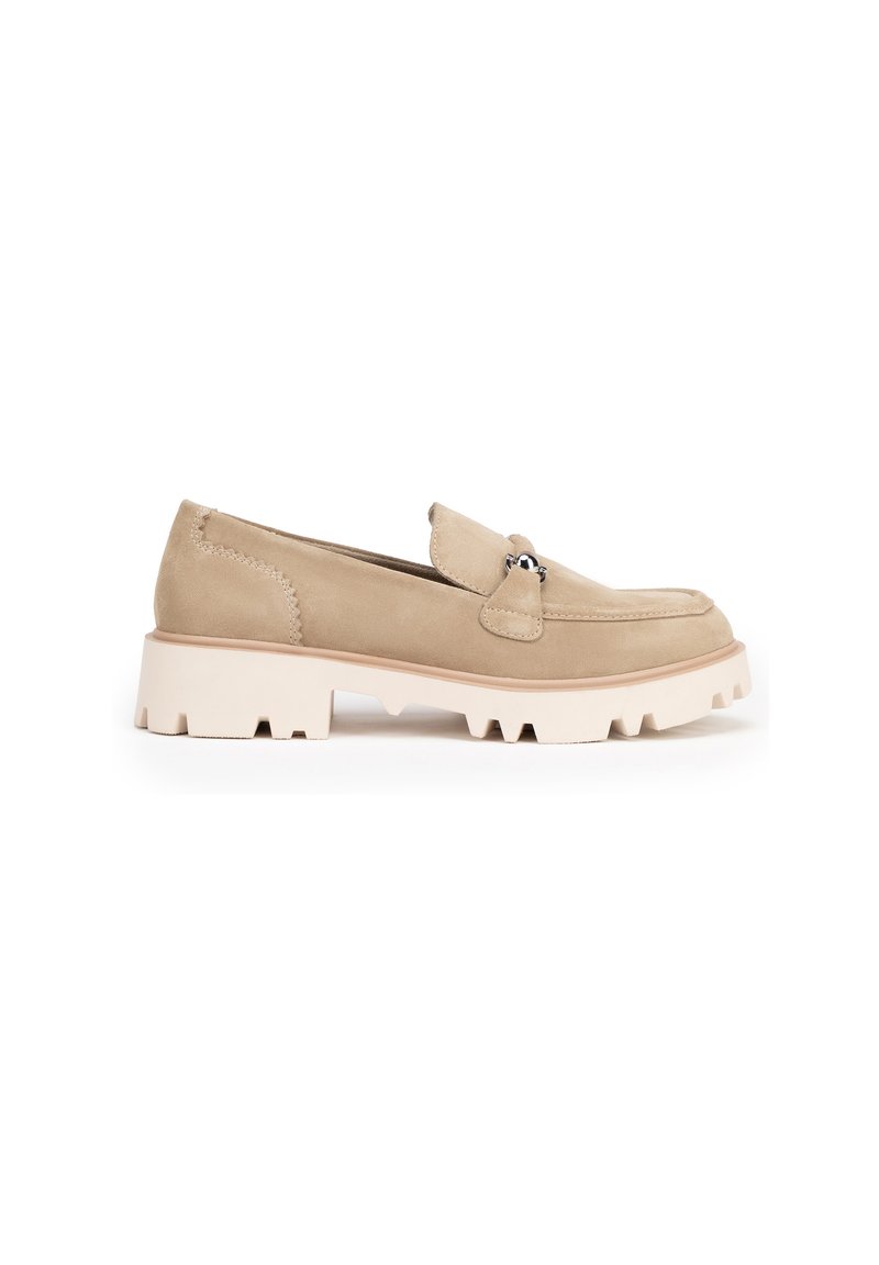 Mocasín de ante beige con punta redonda, pequeña solapa superior, herrajes plateados y suela de goma blanca gruesa con borde serrado.