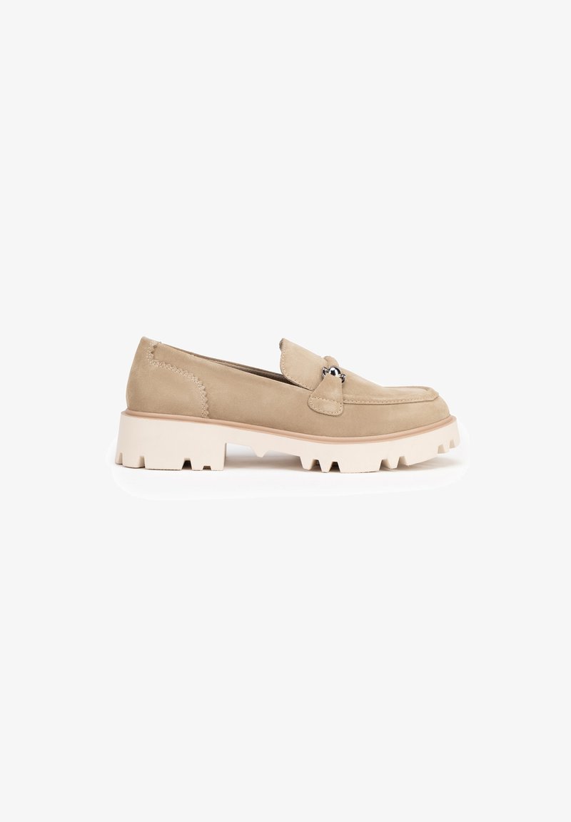 Beige suède loafers met een ronde neus, een kleine bovenflap, zilveren hardware en een stevige witte rubberen zool met een getande rand.