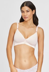Light pink wireless bra with triangular cups, thin straps, and a lacy underband. Features a small bow detail at the center. Soft fabric texture.