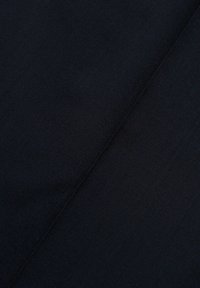 Dunkelmarineblauer Stoff mit glatter Textur, der ein dezentes Gewebemuster und diagonale Falten aufweist, die Tiefe und Struktur anzeigen.