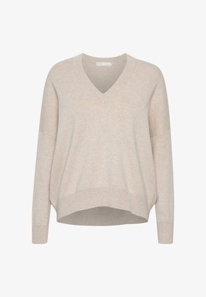 Pull en v beige avec épaules tombantes, manches longues et coupe décontractée. Tissu doux et texturé avec un ourlet légèrement cropped.