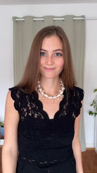 Svart spets-topp med korta ärmar, vågformad halsringning, lager-på-lager texturer, kombinerad med ett kraftigt vitt och guldpärlat halsband.