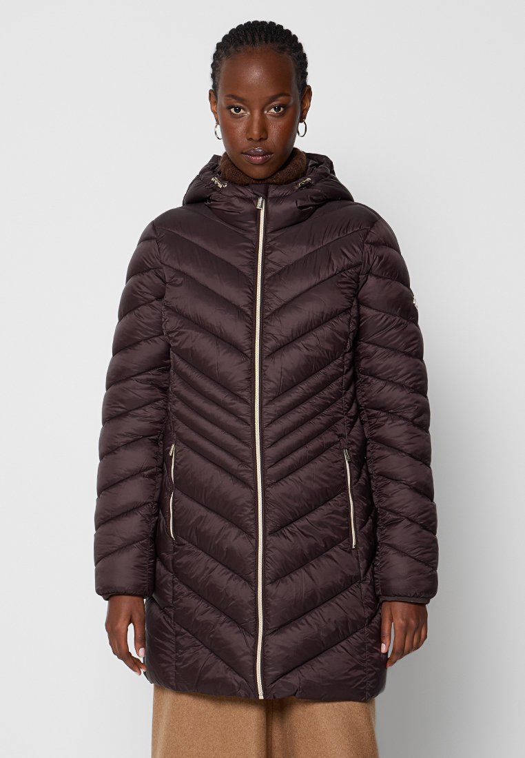 Brązowy puchowy płaszcz z wzorem w zygzak, zapinany na zamek z przodu, z kapturem. Posiada boczne kieszenie i złote akcenty z metalu.