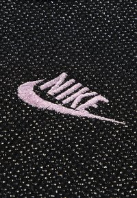 Čierny textil s textúrovaným povrchom a trblietavým efektom. Výrazné ružové vyšívané logo "Nike" umiestnené v strede.