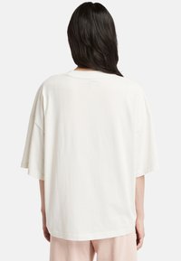 Överdimensionerad t-shirt i off-white färg gjord av mjukt tyg, med rund hals och korta ärmar, i en avslappnad passform utan synliga mönster.